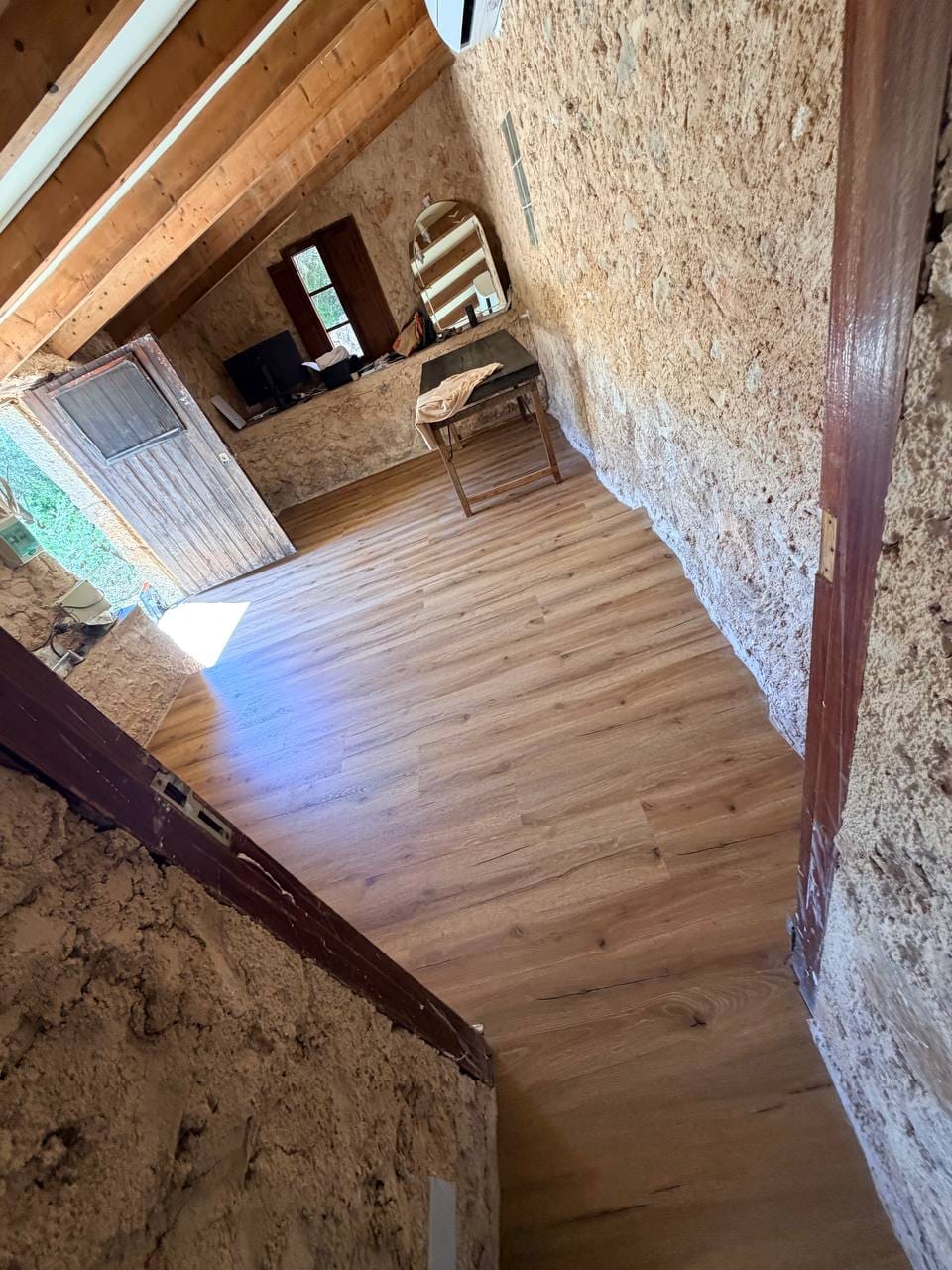 Sanierter Raum mit neuem Boden und Natursteinwand